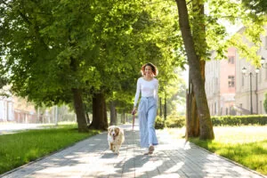 young-woman-walking-with-australian-shepherd-dog-in-the-park